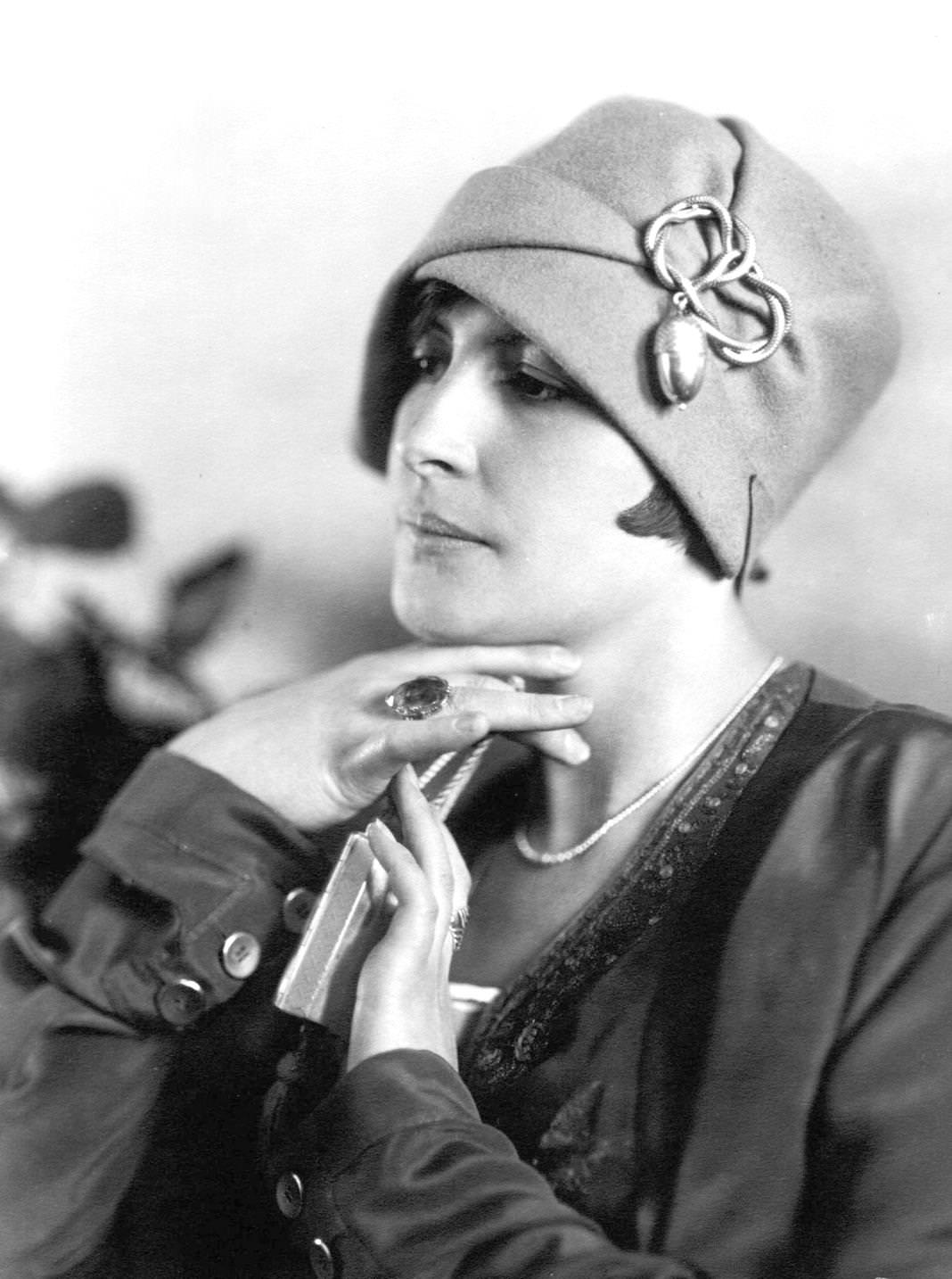 A young woman modelling a cloche hat with a decoration featuring an acorn design, 1925.