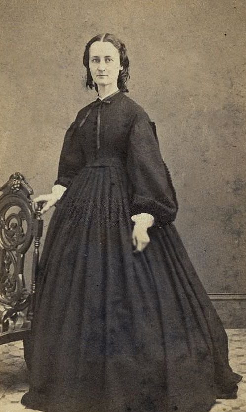 A woman wearing the extremely full-skirted fashion which relied on hoops and crinolines under the dress, 1860
