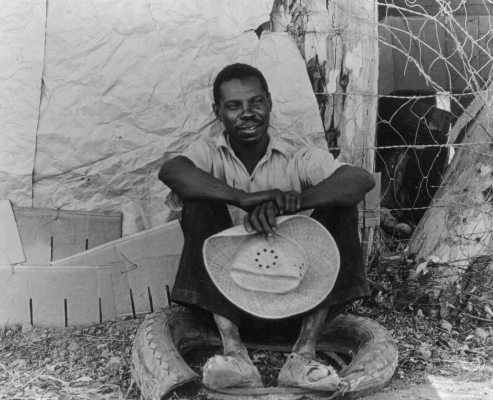 A field worker in Holtville, Imperial Valley, California. He has just made himself shoes out of that old tire, 1930s