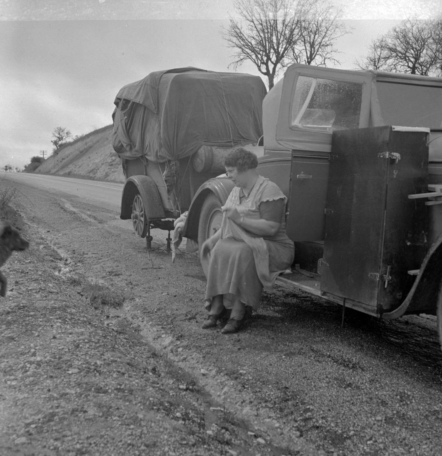 Migrant pea workers on the road. All their worldly possessions in car and trailer, 1930s