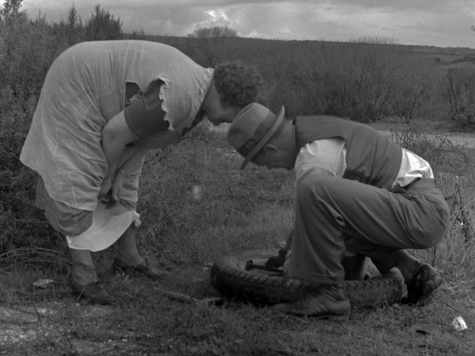 Migrant pea workers on the road with tire trouble, 1930s