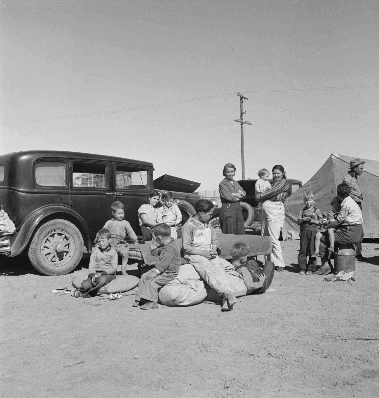 Four families, three of them related with fifteen children, from the Dust Bowl in Texas in an overnight roadside camp near Calipatria, California, 1935