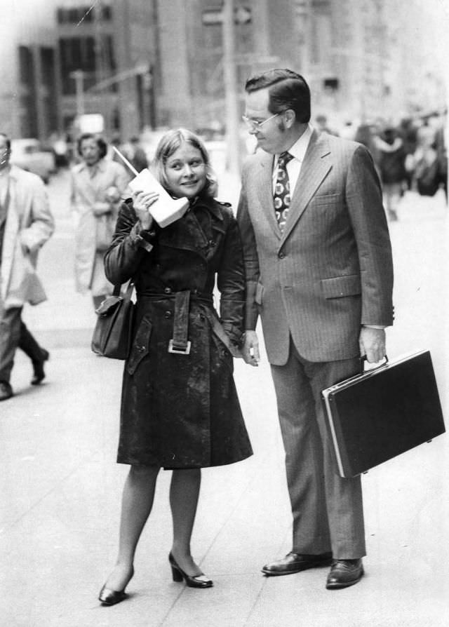 Jeanne Bauer walks with a DynaTAC on 6th Avenue in New York, accompanied by John Mitchell, the Motorola engineer behind the phone, 1973.
