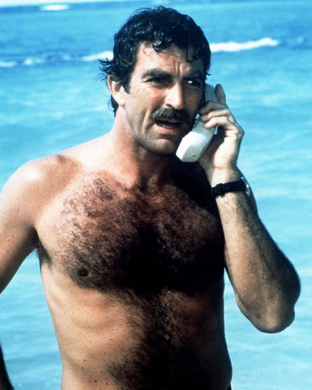 Tom Selleck, playing private investigator Thomas Magnum, makes a mobile phone call from the beach in the TV series “Magnum PI.” 1985.