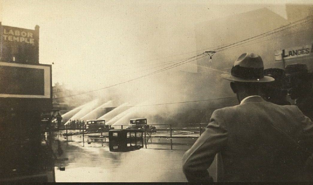 Firefighters spraying water onto building fire, 1935