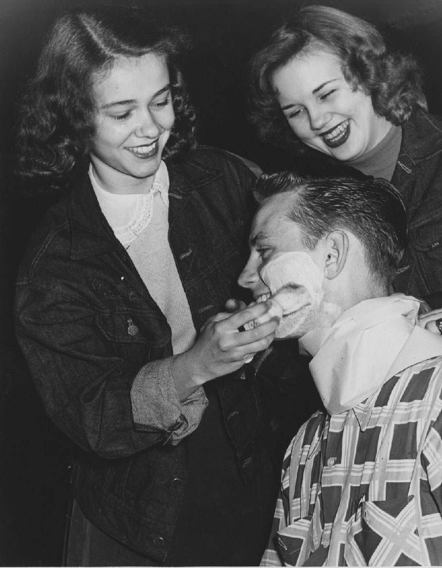 Student shaves another student's beard, 1950s