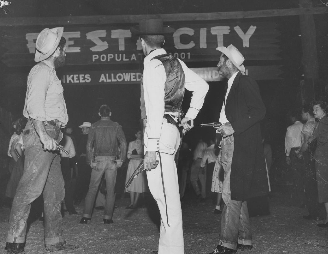 Students dressed as outlaws near the Fiesta City gate, 1950s