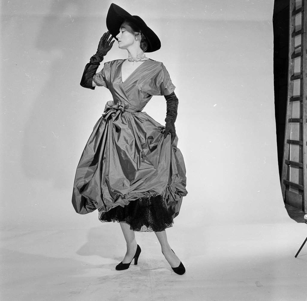 A model posing, wearing clothes, a dress, from Carven, Jean Desses, Jacques Fath, Jeanne Paquin, 1951