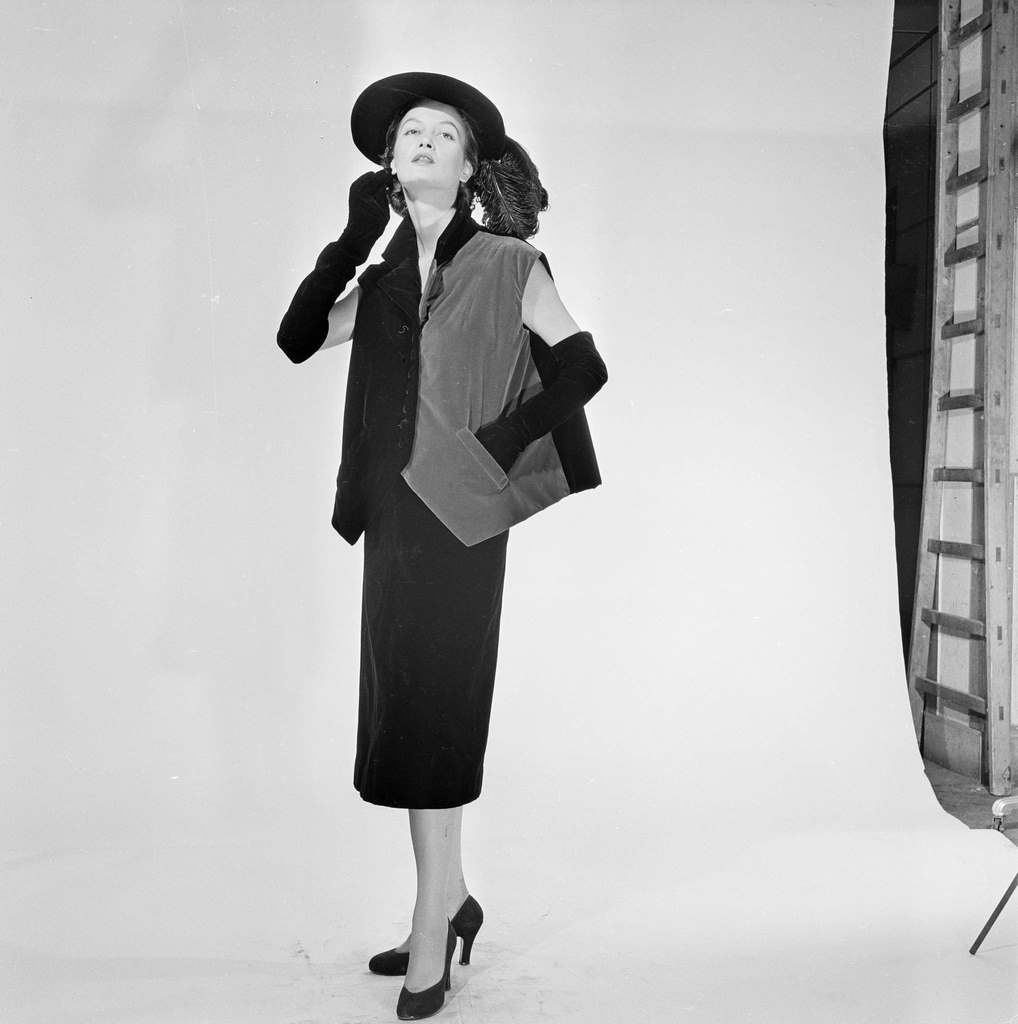 A model posing, wearing clothes, a suit, from Carven, Jean Desses, Jacques Fath, Jeanne Paquin, or Robert Piguet, in the studio, 1951