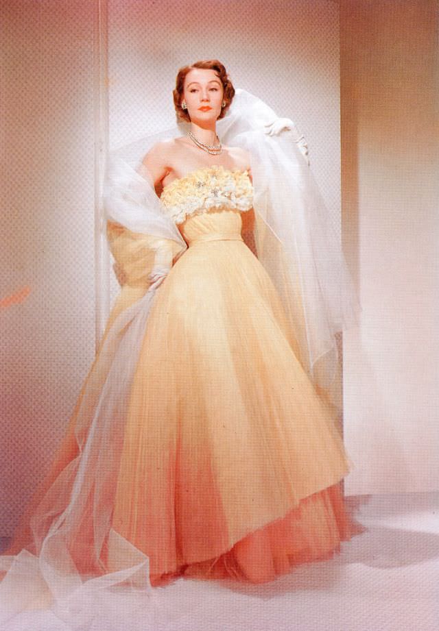Sophie Malgat in Fath's dégrade orange pleated tulle evening gown with floral bodice called "Sunbeam", April 1951