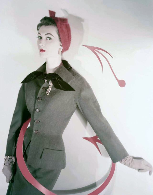 Dovima wearing a taupe wool and velvet suit by Ben Zuckerman with a red hat by Jacques Fath, photo by Horst P. Horst used for cover of Vogue, 1953