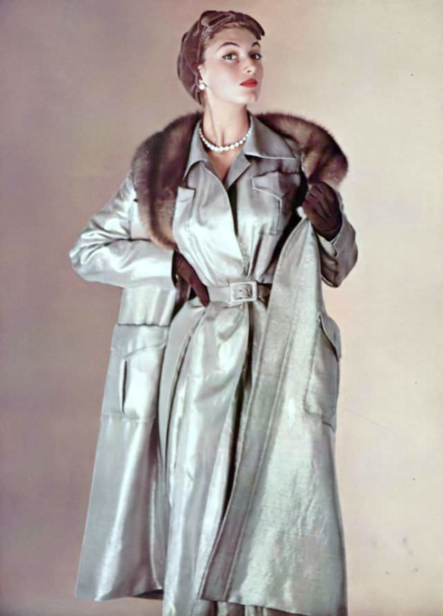 Marie-Hélène in silver lamé ensemble, the coat is lined in quilted brown satin, the collar is sable, large pockets hang on each side, worn with small brown velvet cap, by Jacques Fath, 1954