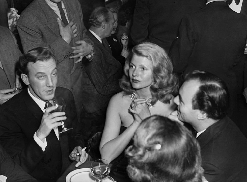 Rita Hayworth, French fashion designer Jacques Fath and Ali Khan in Paris, France in 1949.