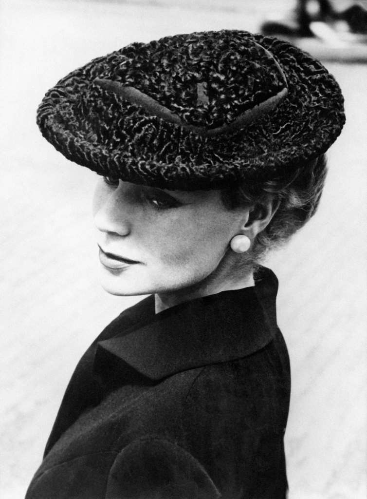 Round hat in gray astrakhan from South Africa. The encrusted grosgrain forms the crown. This model is worn forward on the forehead. Created by Jacques Fath, Paris 1955.