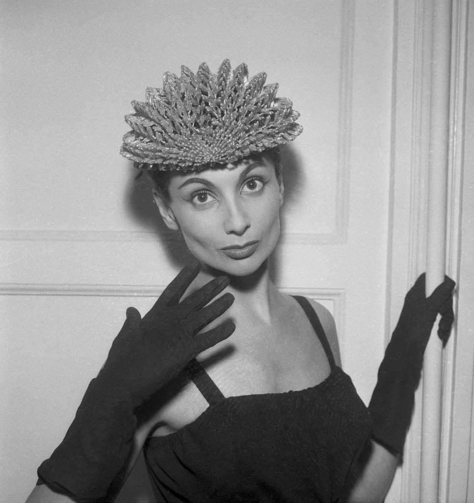 Model presenting a model by Jacques Fath, a spring hat and gloves, in Paris, France on January 28, 1957.