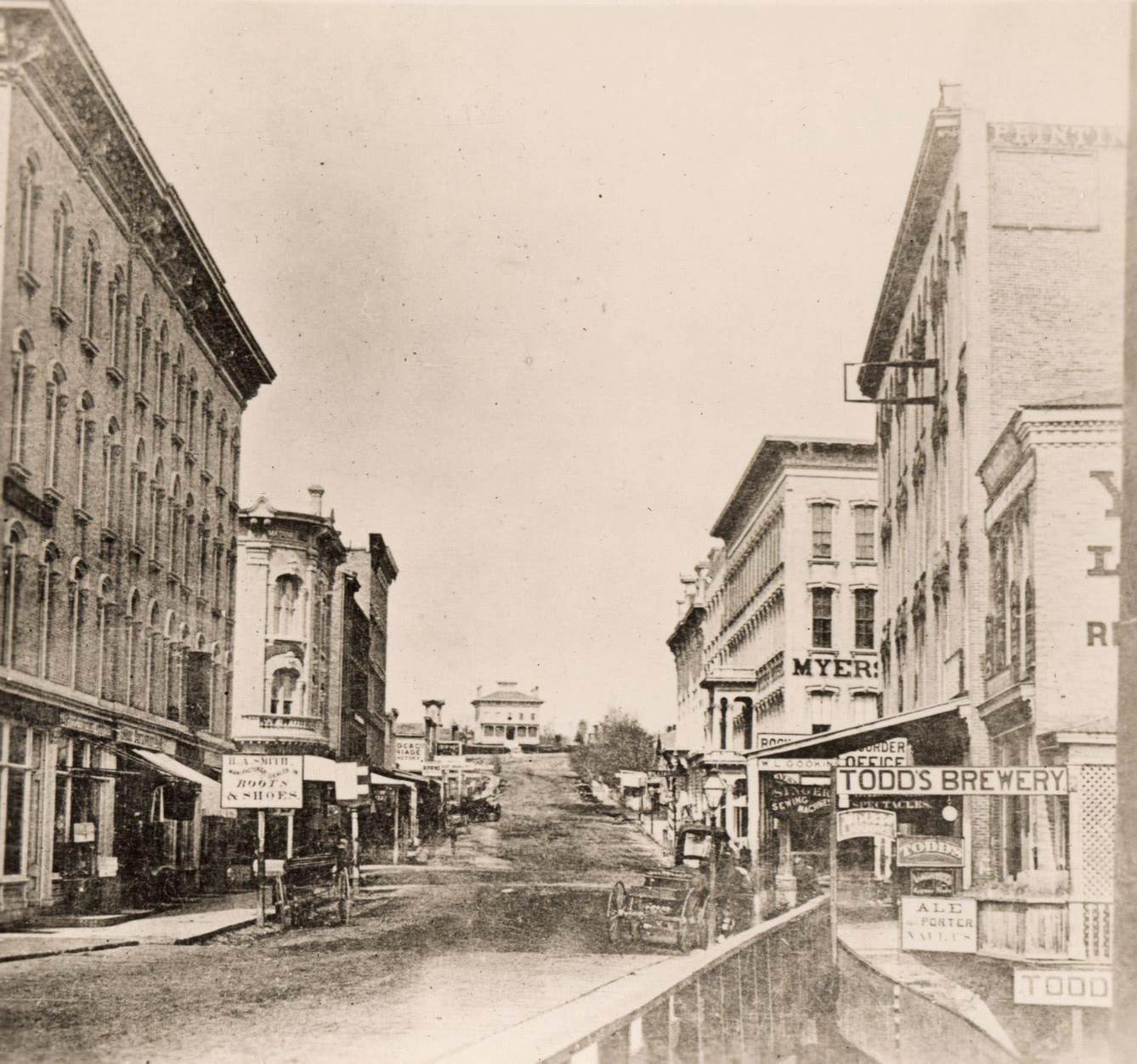 Milwaukee Street looking east in Janesville, Janesville, Wisconsin, 1870. The Myers House is located at the top of the hill.