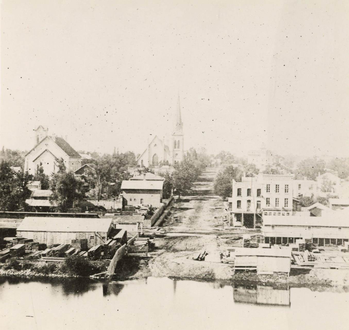Elevated view over river of Dodge Street in Janesville looking west, Janesville, Wisconsin, 1870.