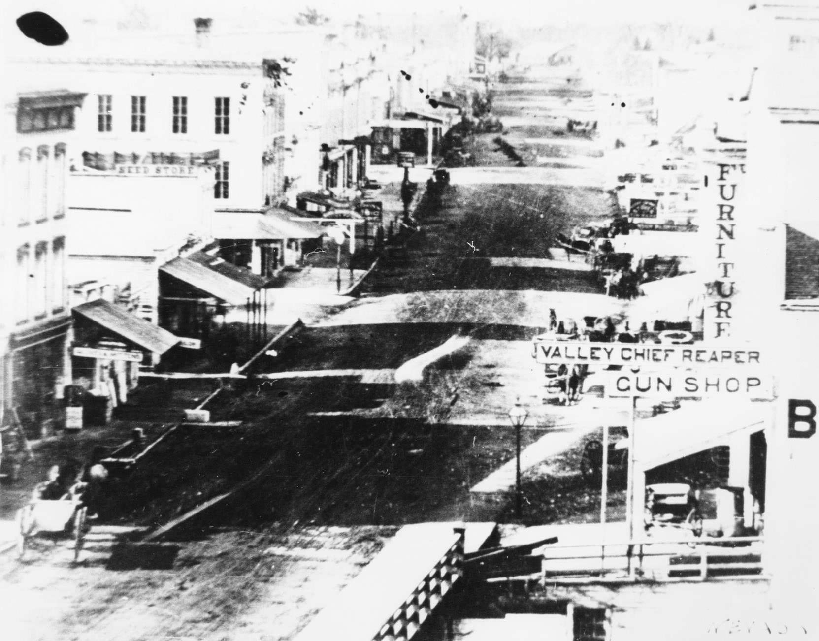 Milwaukee Street looking west from the Jackman Building includes a horse and buggy, the Valley Chief Reaper Gun Shop, and a furniture store, 1850