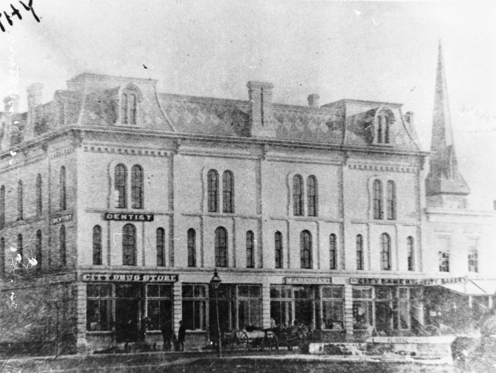 A building with a mansard roof at the corner of Franklin and Milwaukee Streets in Janesville, 1890