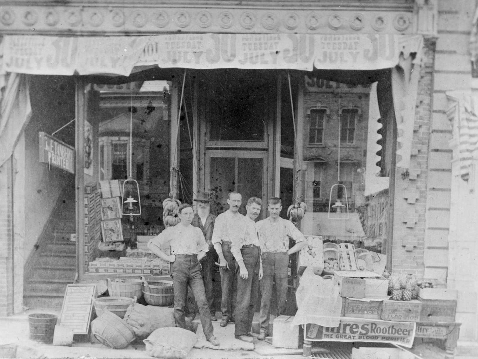 Five men outside their grocery store on River Street in Janesville, 1890.