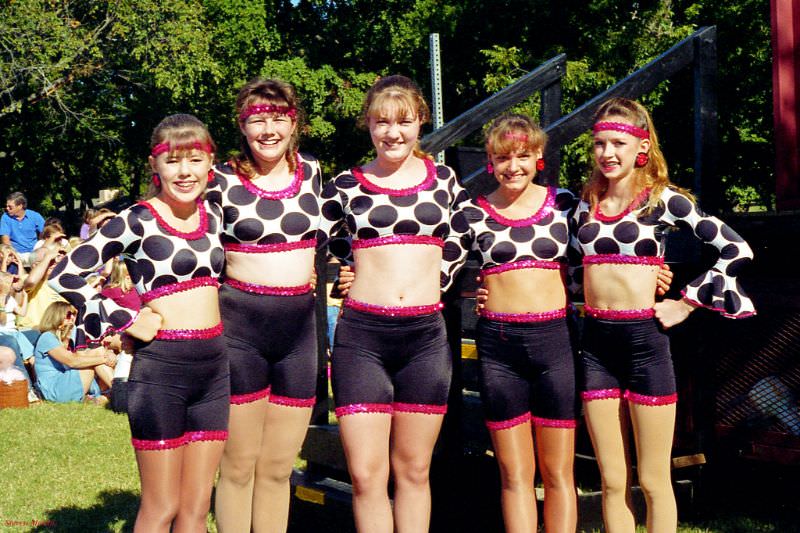 A group of young teenage girls pose after a dance performance during a festival at Bear Creek Park, Keller, Texas, 1995