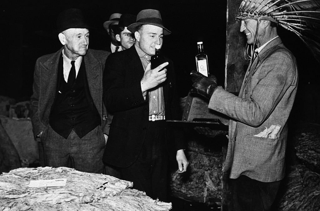 Farmers listening to a patent medicine salesman during a tobacco auction in Durham, North Carolina, November 1939