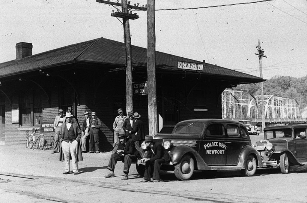 A group of men standing in front of a railway station in Newport, Tennessee, November 1939