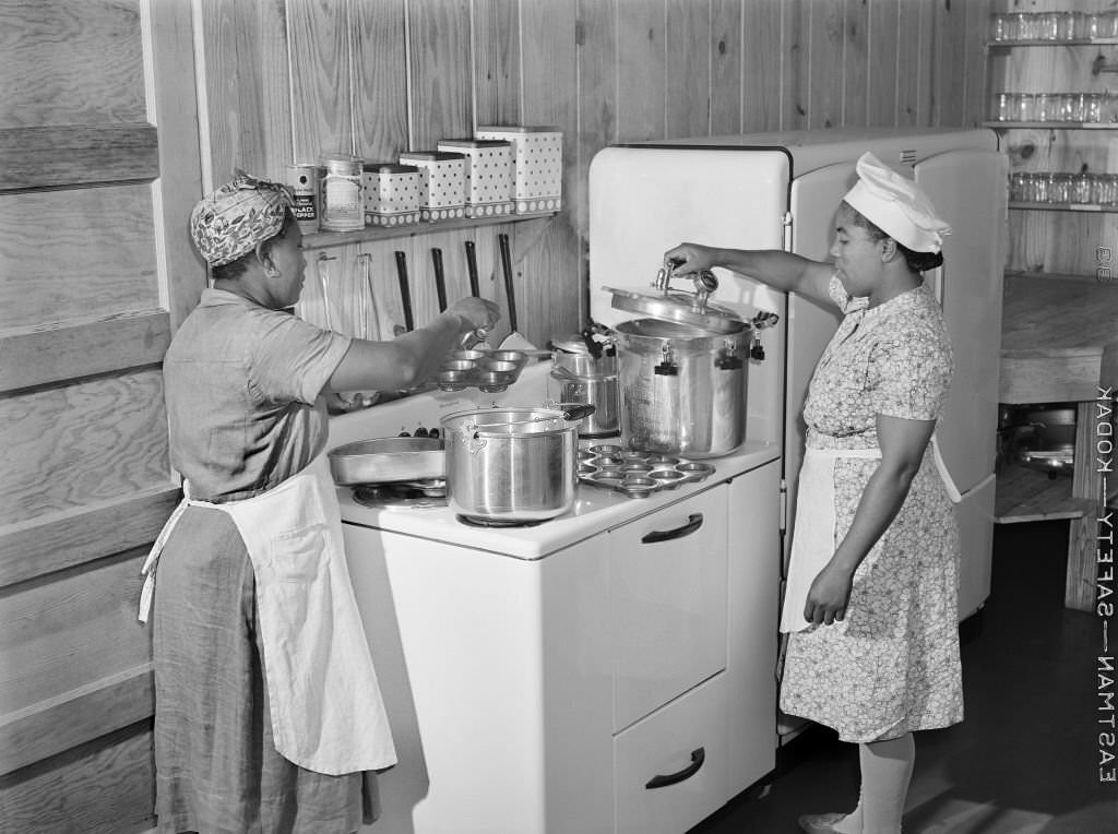 Two Female Workers preparing Hot Lunch for Agricultural Workers' Children in Kitchen of Day Nursery, Okeechobee Migratory Labor Camp, Belle Glade, Florida, February 1941
