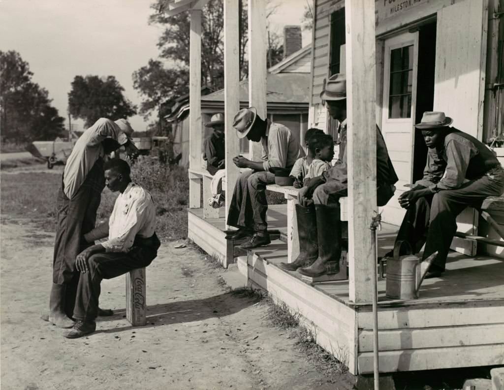 Haircutting in front of General Store and Post Office on Marcella Plantation, Mississippi, 1939