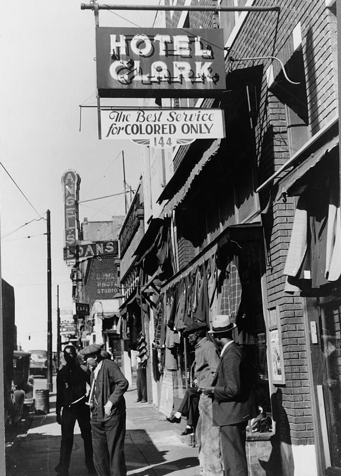 Men on the sidewalk in front of a secondhand clothing store on Beale Street, Memphis, Tennessee, 1939.