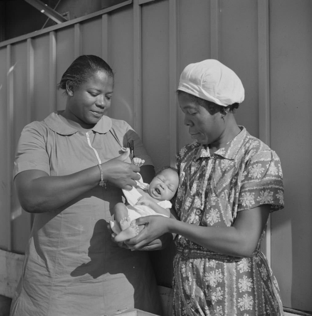 Nurse Examining Infant with Mother and Child Receiving Prenatal and Postnatal Care, Florida, June 1940