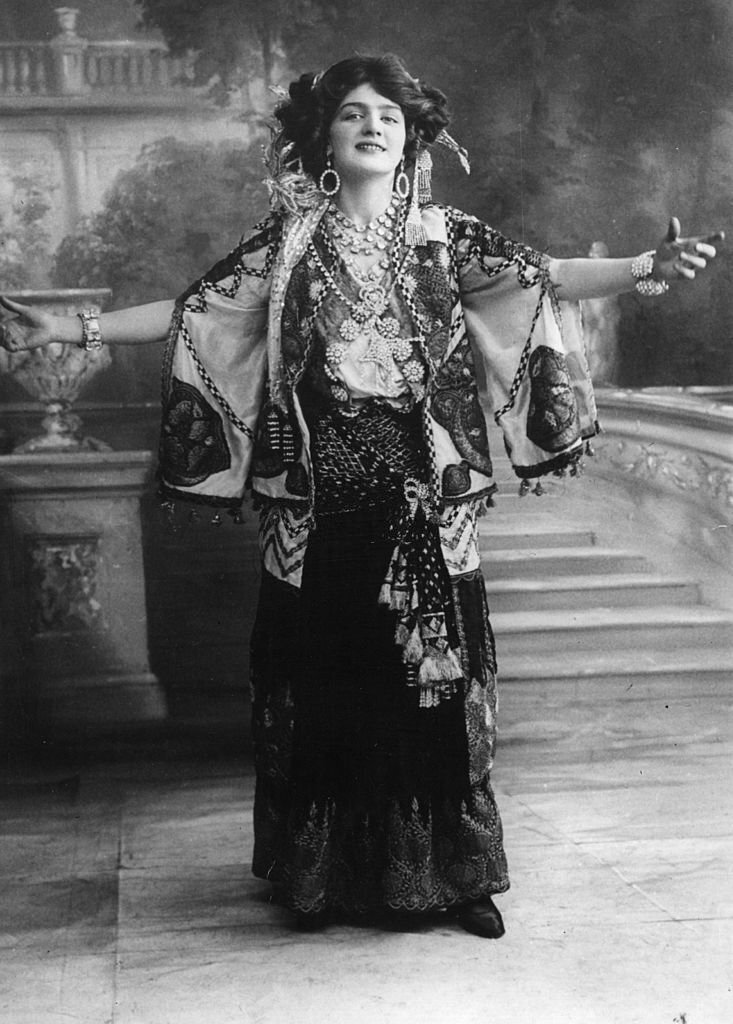 Lily Elsie with arms outstretched, in a scene from the musical play 'The Merry Widow', 1907