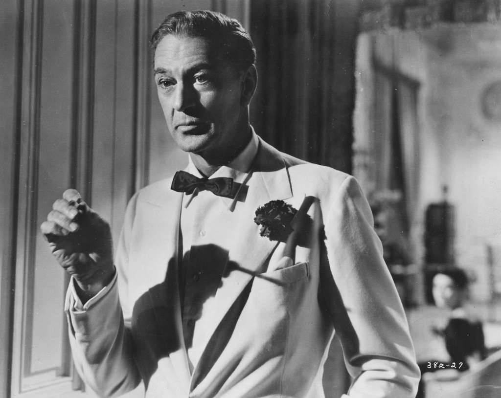Gary Cooper, wearing a tuxedo and a button hole, and smoking a cigarette, in a scene from the movie 'Love in the Afternoon', 1957.
