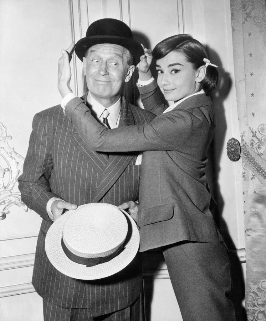 Maurice Chevalier has his hat adjusted by Audrey Hepburn in a scene from the film 'Love In The Afternoon', 1957.