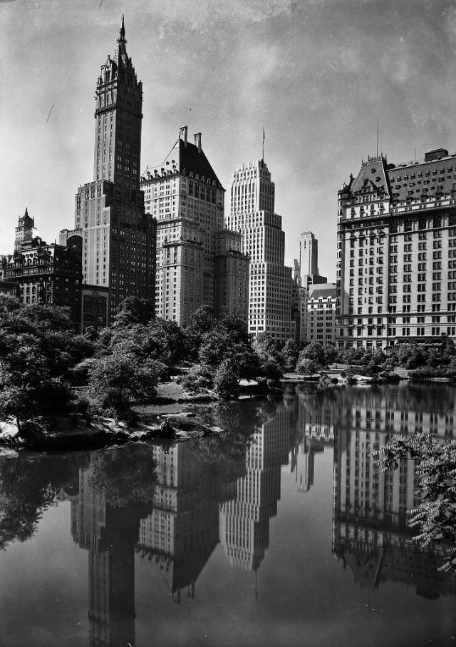 View of plaza buildings, over park lake, New York City, January 1933