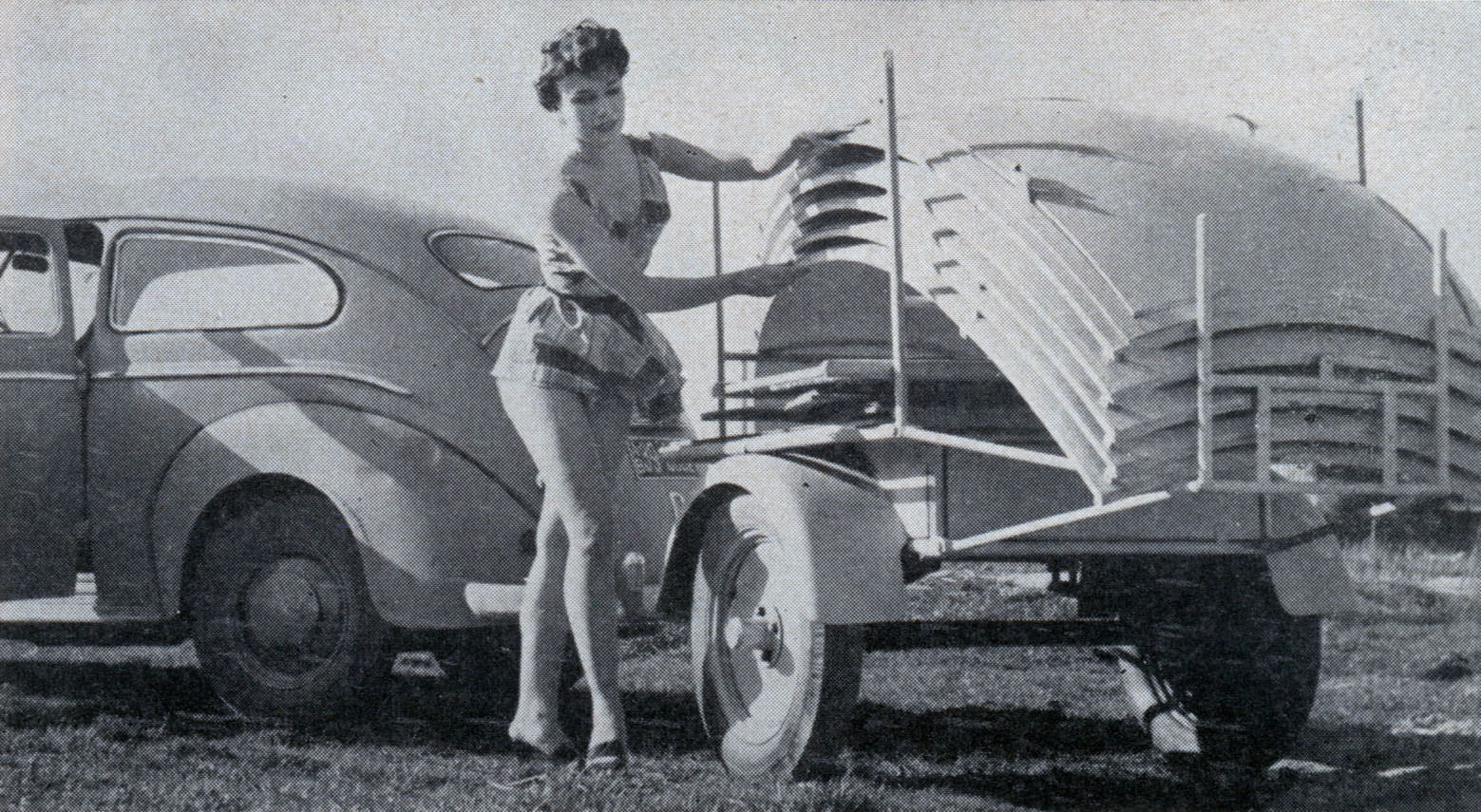 Attractive camper stacks the parts of the port-able shelter on a small trailer.