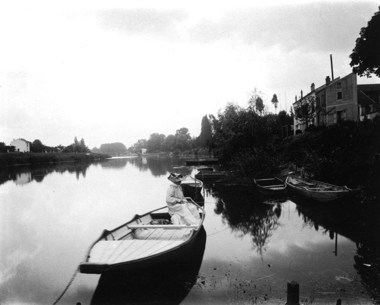 Les Bords du Marne. A woman fishing on a rowboat in the Marne River, 1912