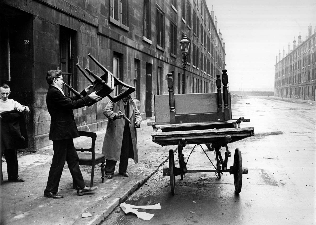 A man piling furniture onto a cart in a street of soon-to-be-demolished tenements in the Gorbals area of Glasgow, 1960