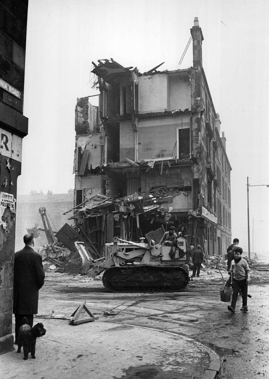 A workman in a bulldozer in front of a tenement being demolished in the Gorbals area of Glasgow, 1960