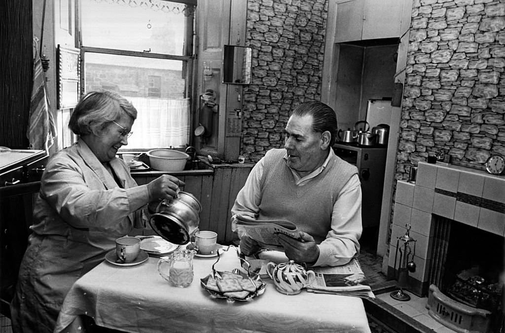 Mr and Mrs Curran sitting having tea in the kitchen of their soon-to-be-demolished tenement home in the Gorbals area of Glasgow, 1960s