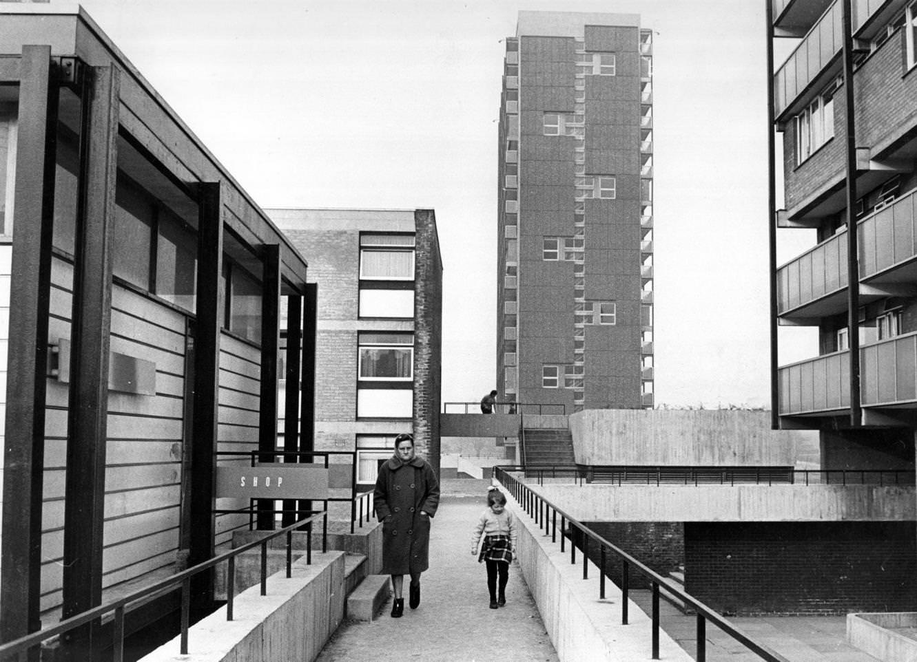 A woman and a little girl walking through an area of modern housing in the Gorbals area of Glasgow, 1960