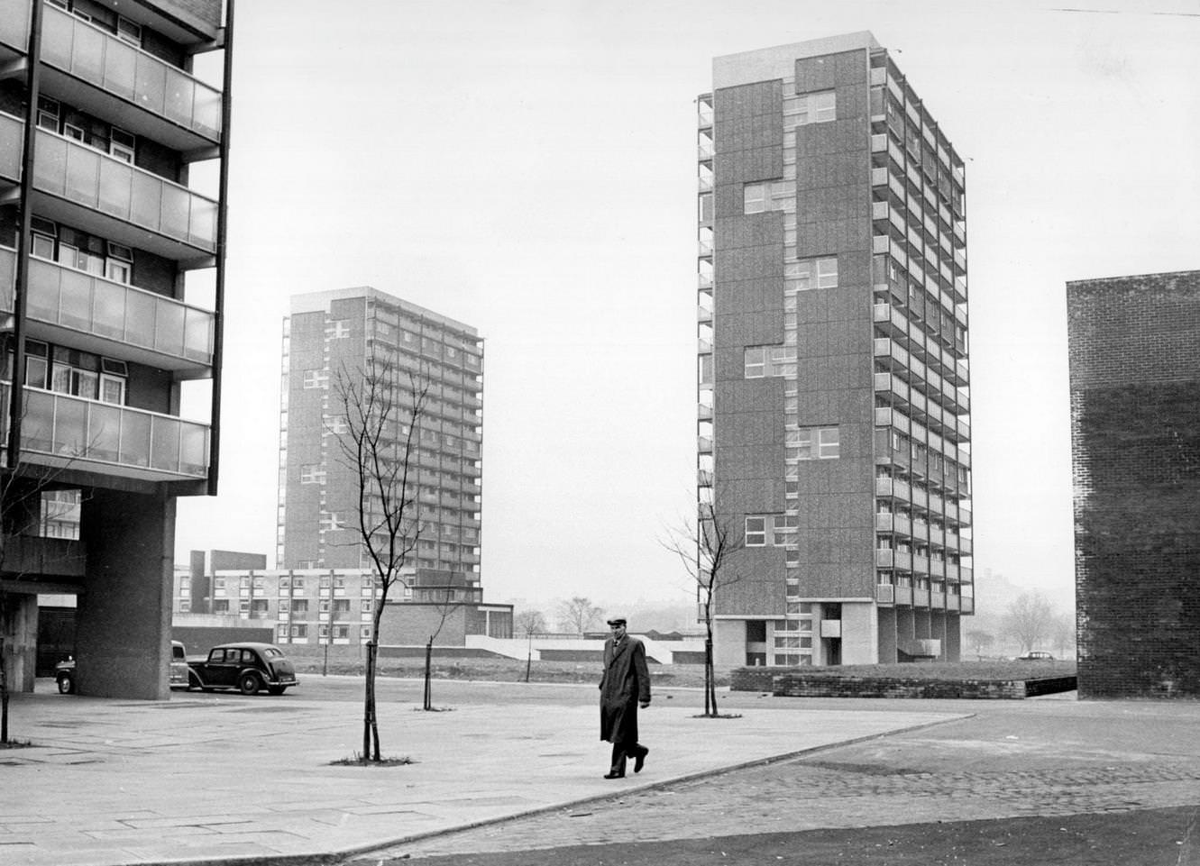 A man walking past modern tower blocks in the Gorbals area of Glasgow, 1960