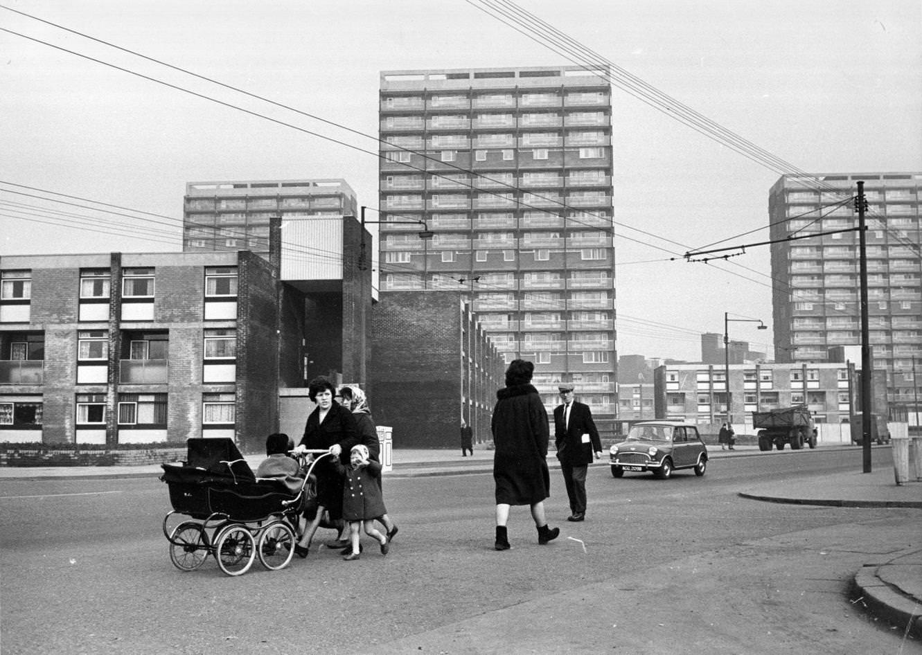 People walking past newly-built tower blocks in the Gorbals area of Glasgow, 1960