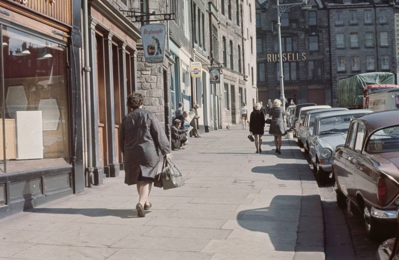 Pedestrians walk up a city street in the Grassmarket area of the Old Town in Edinburgh, Scotland, 1965.