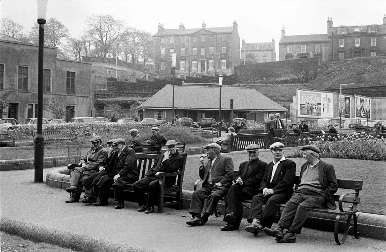 Retired men sitting on park benches in Greenock, Scotland, 1964.