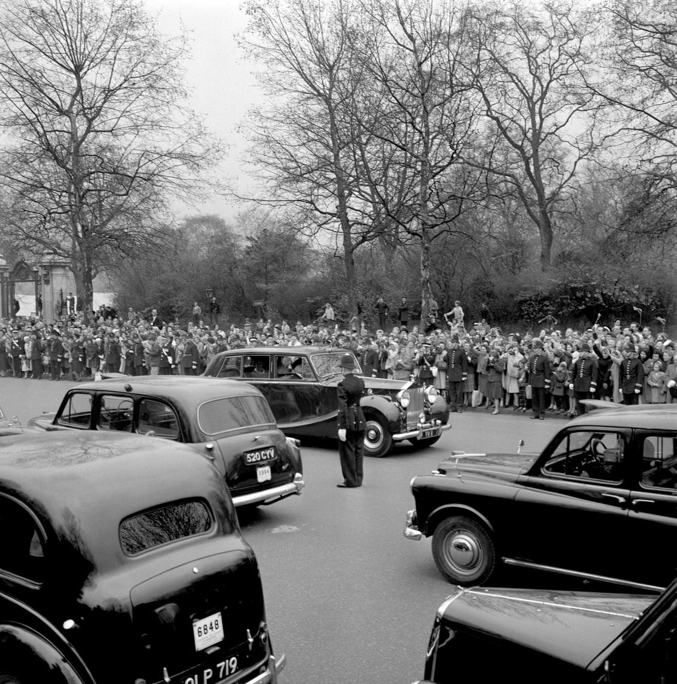 Mall traffic is brought to a standstill as the car carrying Princess Alexandra of Kent and her husband Angus Ogilvy sweeps out from St James's Palace, 1963