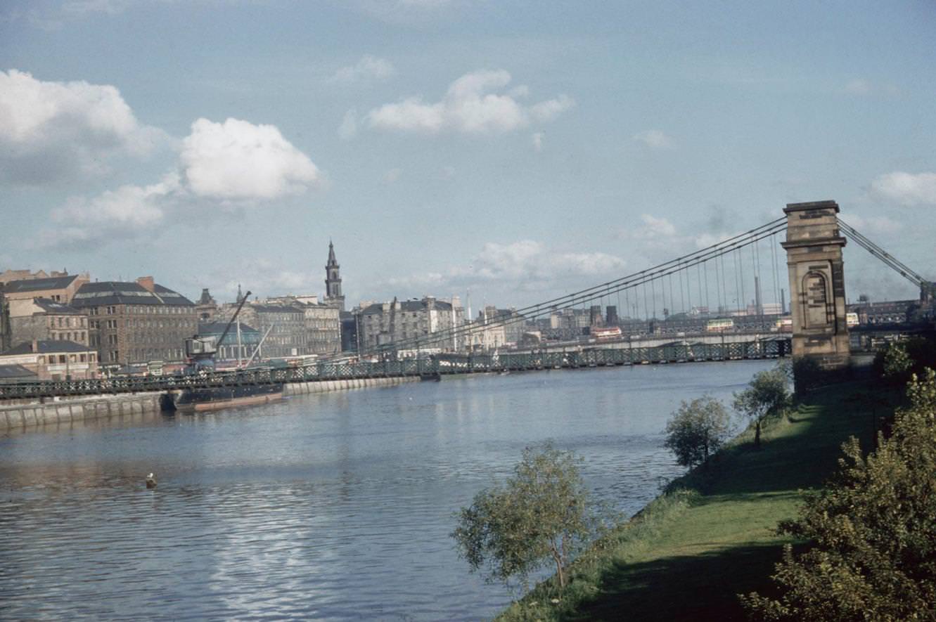 The south bank Laurieston and Gorbals area of the South Portland Street Suspension Bridge spanning the River Clyde in Glasgow, Scotland, 1965.
