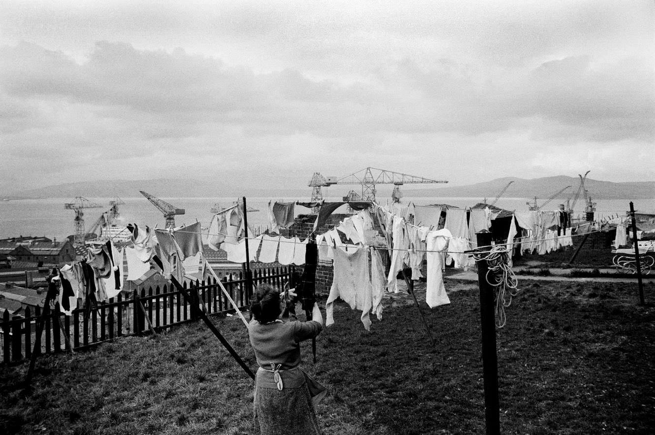 A woman hanging out her washing on a line in Greenock on the Clyde, Scotland, 1963.