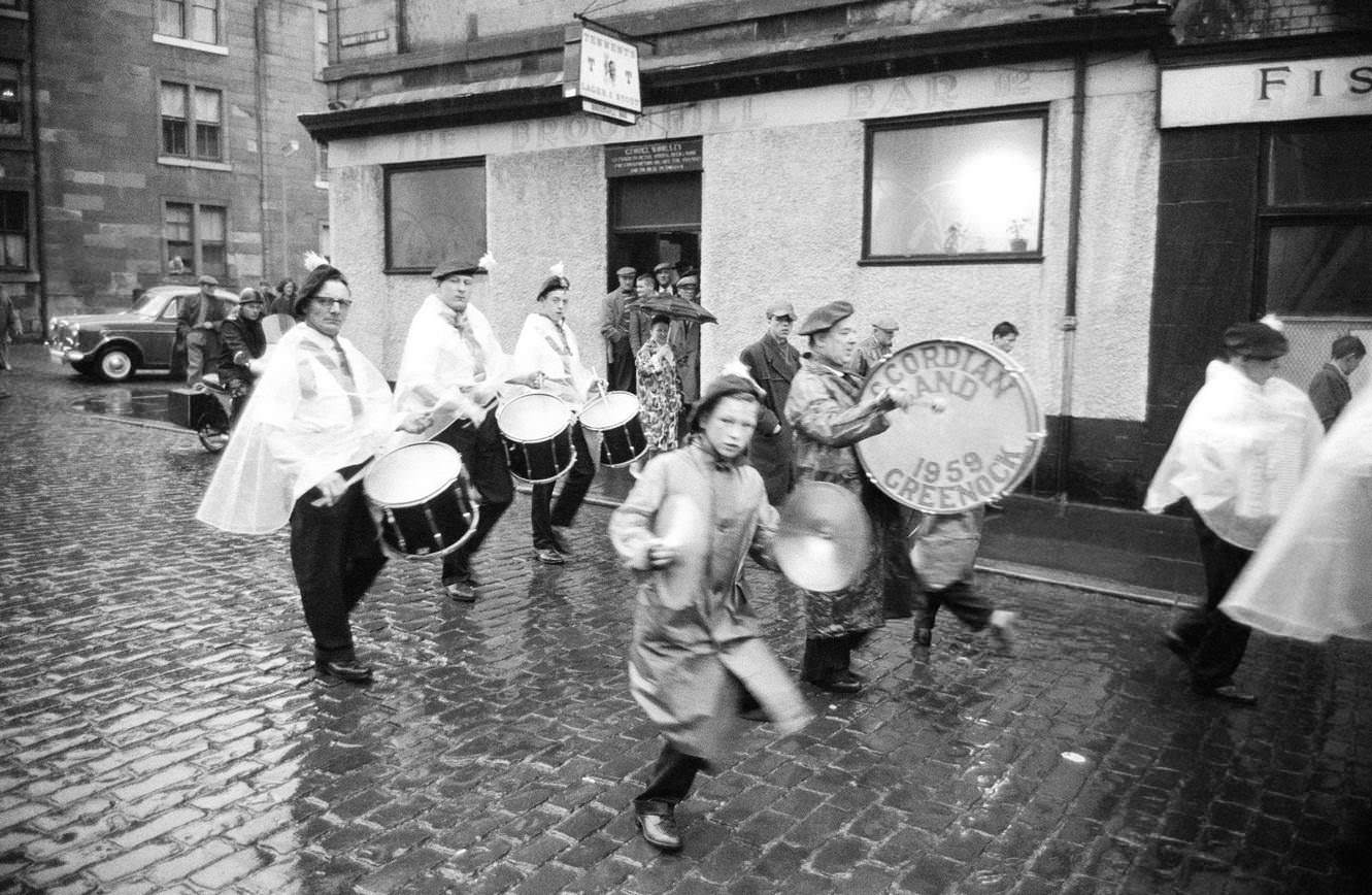 Drummers of the Greenock Accordian Band marching in the rain, Greenock, Scotland, 1963.