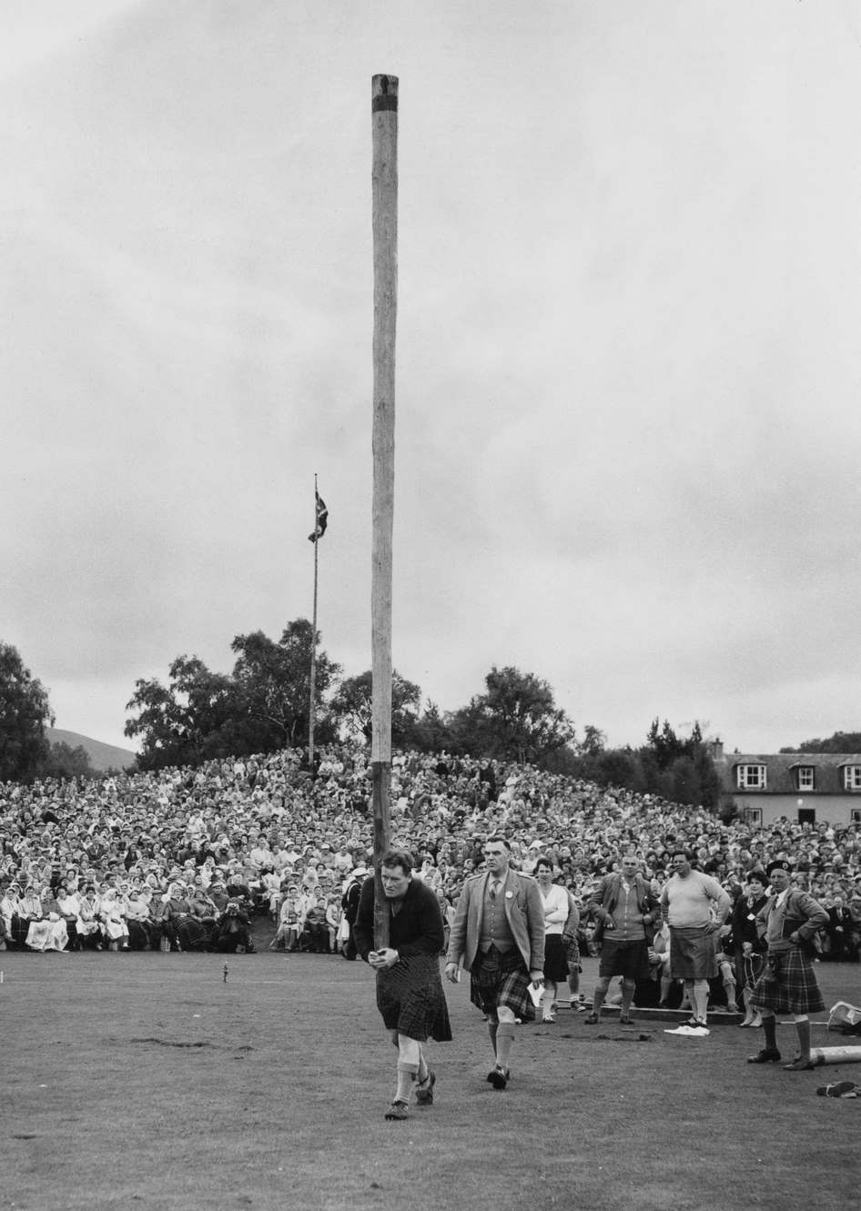 British Highland Games athlete Bill Anderson watched by officials as he competes in the caber toss event of the Braemar Gathering in Braemar, Aberdeenshire, Scotland, 9th September 1961.